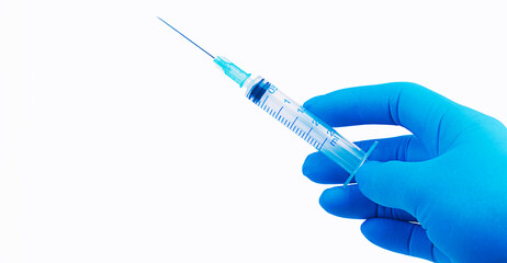 Hand in blue glove holding syringe on grey background with copy space. Medical treatment concept. Vaccination concept. 