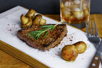 Fresh grilled meat.Beef steak medium rare with rosemary brunch and mashrooms on wooden cutting board