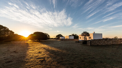 Ein idyllischer Sonnenaufgang über den weißen Ferienhäusern des De Hoop Nature Reserves in...