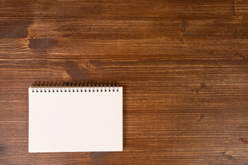 A blank notepad on a wooden background surface	