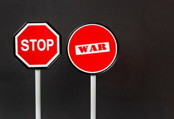road signs on a black background with the inscription stop war