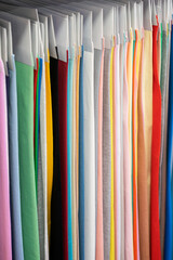 Colorful fabric samples in row on hanger. Sewing clothes, hobby concept
