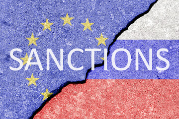 The crack between the Russian Federation and European Union flags. The concept of sanctions.