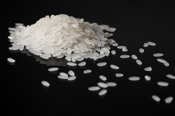 Pile white rice on black background. close up
