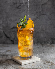Refreshing iced tea with orange slices and mint