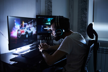 a young 30-year-old gamer is sitting at a computer, playing computer games, nervous, angry, worried.selective focus with low depth of focus