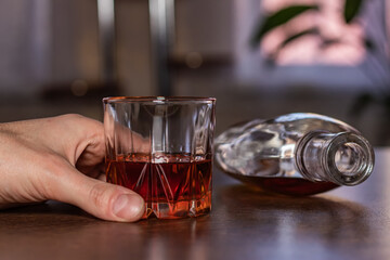 Alcoholism, man hand takes a glass of alcohol, holding glass of whiskey alone. Treatment of alcohol addiction, suffer abuse problem alcoholism concept