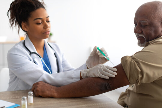 Senior Patient Getting Vaccinated Sitting In Medical Center