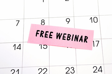 Text Free Webinar written on a pink sticky note posted on a calendar or planner page. Deadline concept read a reminder on calendar date
