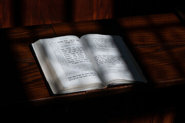 An open Jewish prayer book or siddur lies on a prayer stand in a synagogue in Israel.