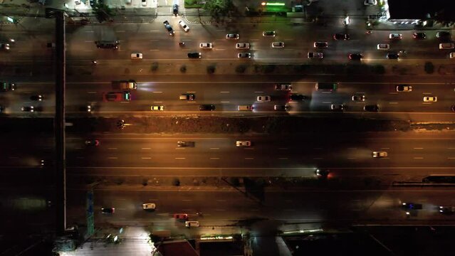 aerial view of car traffic transportation above road traffic jam and highway in Asian city night. Drone aerial view fly in circle, high angle. Public transport or commuter city life concept