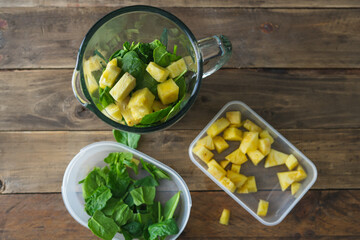 Blender glass with spinach and pineapple. Preparation to make a healthy smoothie. Copy space.