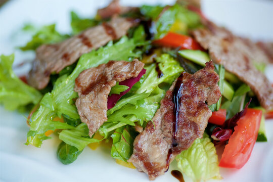 Salad with fried meat and fresh vegetables. A dish from a chef in a restaurant.