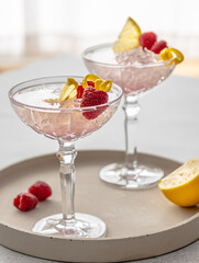 Pink cocktail decorated with raspberries