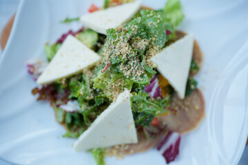 Salad of fresh vegetables and cheese with white sauce. Dishes from the chef in the restaurant.