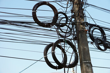 Electric wires, telephone lines and internet cables were tied in roll on concrete pole at...