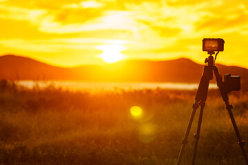 Naklejka premium Camera taking picture of sunset over sea