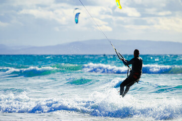 Kite surfer riding waves. Kiteboarding sport.
