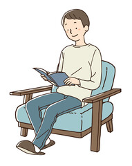 青いソファに座り読書をする男性