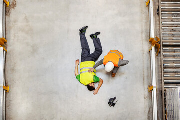 Top view of supervisor with injured unconscious warehouse worker.