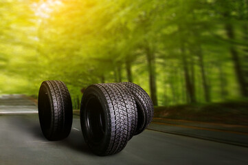 Change a car seasonal tire summer forest road with trees background. Change for winter tire. Banner...