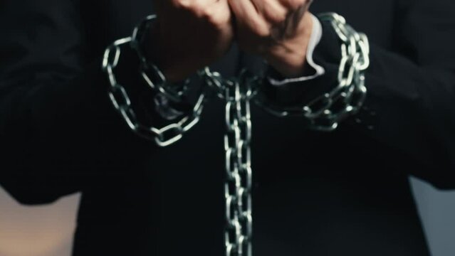 man dressed in jacket with chained hands