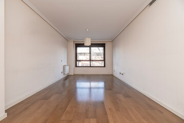 Living room with light oak flooring with white woodwork, white aluminum radiator and black aluminum window