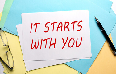IT STARTS WITH YOU text on paper on the colorful paper background