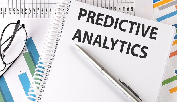 PREDICTIVE ANALYTICS pen and glasses on chart, business concept