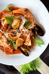 Seafood pasta - shrimp, clams and octopus served with cheese and basil leaves and red sauce