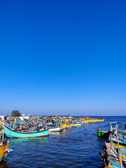 Fototapeta na wymiar Fishing boats anchored near the shore. Blue sea landscape background.