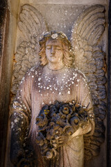 sleeping angel with a bouquet of poppy flowers, Esporles cemetery, Majorca, Balearic islands, Spain