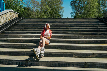 Woman in roller skates sits on steps.