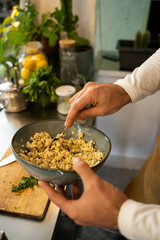 Vertical photo of cook preparing tofu for his vegan dish. 