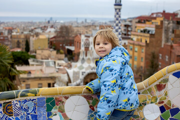 Child, posing in park Guell in Barcelona - obrazy, fototapety, plakaty