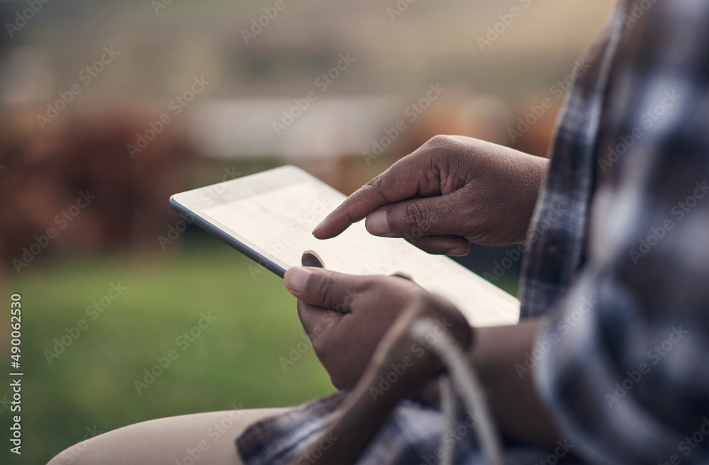 Poster the modern way to manage a farm. shot of an unrecognisable man using a digital tablet while working 