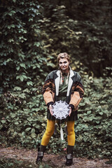 Photo of a girl dressed as a national American. Walk and rest in the summer forest. Entertainment. The game. Fun. Wear a jacket, khaki dress and bright yellow tights. Happy woman.