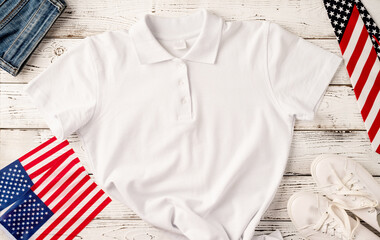 Mockup design white polo t shirt for logo, top view on white wooden background with US flag, shoes...