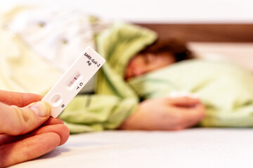 Patient with coronavirus Covid-19 lying in bed with positive test result of antigen test