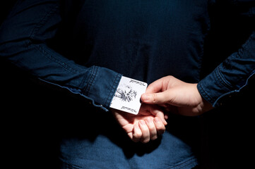 Lviv, Ukraine - 01.03.2022: human hands pulling a joker card from the sleeve