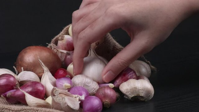 a hand placing some compound bulb of garlics