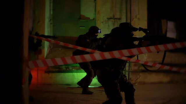Armed Paramilitary Men or a Police Squad Attacks a Terrorist Base. Armed SWAT Police Officers Storm a Dark Seized Basement Shoot on The Run Anti-terrorist Operation