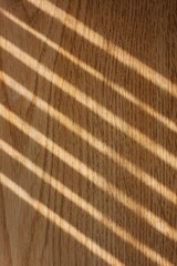 Diagonal shadows of light on the wooden wall.