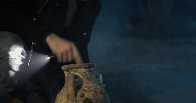 young boy digs into the ground at night and finds a treasure