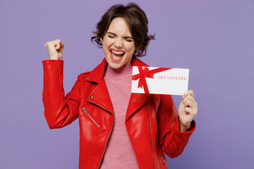 Young overoyed excited happy woman 20s wear red leather jacket hold gift certificate coupon voucher...