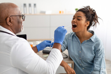 Doctor taking PCR test sample from potentially infected black woman