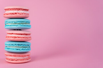 Delicious colorful french cookies macaroons on pink background. Copy space.