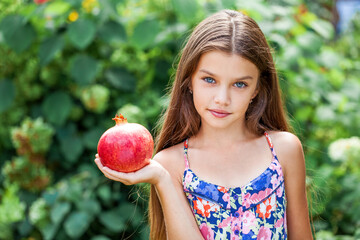 Portrait of a little girl with a pomegranate