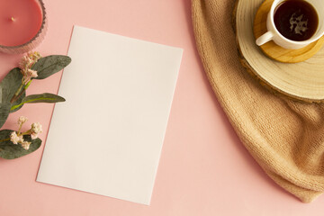 Top view of blank sheet, coffee cup, flowers and candle. Espacio para texto