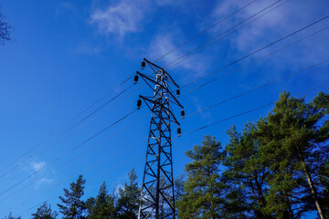 Looking up at a power pylon with blue sky background